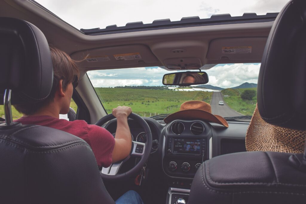 Image of couple inside car looking through front shield and sunroof UV ray